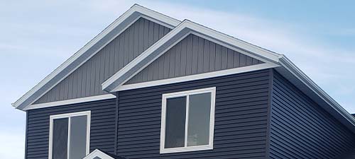 Dark gray and gray-blue house siding with white trim.