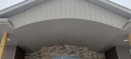Arched gray porch ceiling above stone entryway.